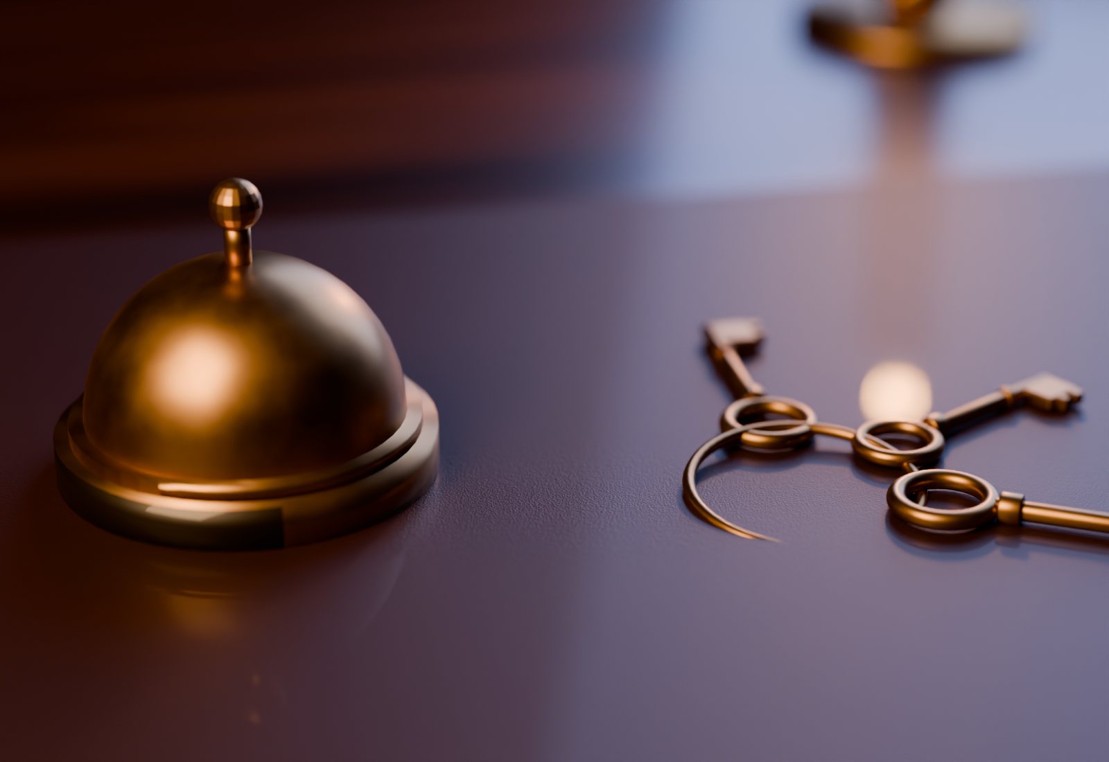 A brass reception bell and a ring of brass keys on a leather desk blotter